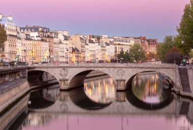 Seine nehri üzerindeki eski taş evler ve gün doğumunda köprü. Paris mi? Fransa.