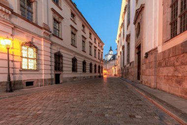 Şafak vakti Wroclaw 'daki Üniversite Meydanı yakınlarında yanan bir fener olan eski dar bir sokak. Polonya.