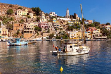 Güneşli bir günde, Symi adasının körfezinde renkli geleneksel balıkçı tekneleri. Simi. Yunanistan.