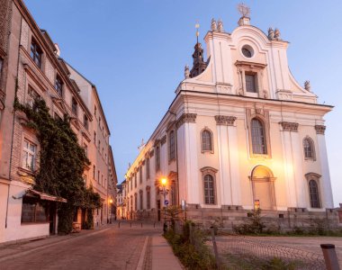 Şafak vakti Wroclaw 'daki Üniversite Meydanı yakınlarında yanan bir fener olan eski dar bir sokak. Polonya.