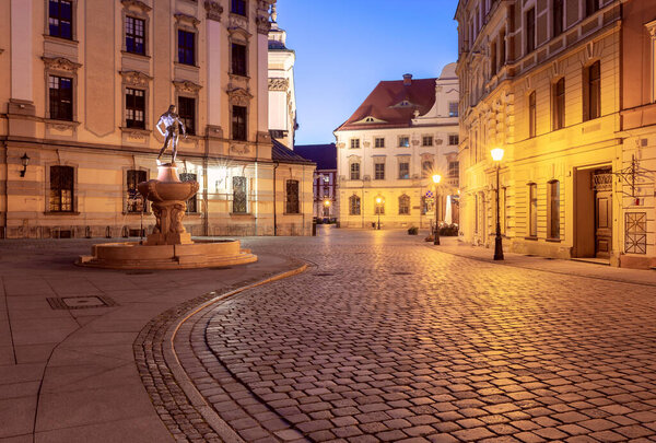 University Square with a fountain in Wroclaw at dawn.