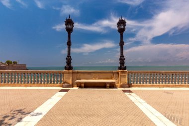 Güneş ışığında eski fenerlerle Cadiz 'in taş gezinti alanının manzarası. İspanya. Endülüs.