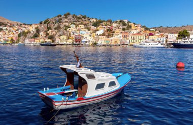 Güneşli bir günde, Symi adasının körfezinde renkli geleneksel balıkçı tekneleri. Simi. Yunanistan.