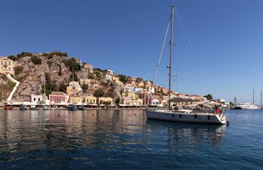 Güneşli bir günde, Symi adasının körfezinde beyaz zevk yatı. Simi. Yunanistan.