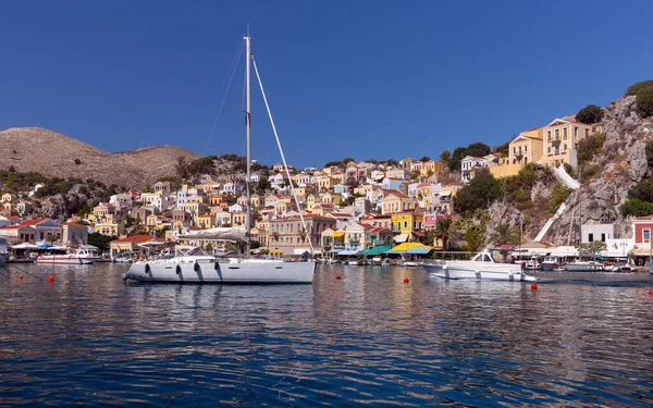 Güneşli bir günde, Symi adasının körfezinde beyaz zevk yatı. Simi. Yunanistan.