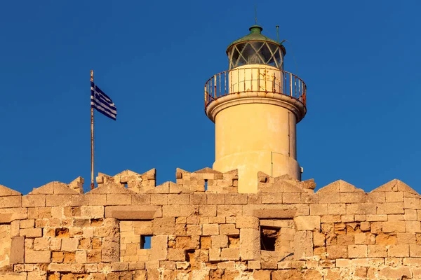 View of the old stone lighthouse at Fort St. Nicholas in Rhodes at sunset. Greece.