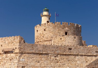 Gün batımında Rodos 'taki St. Nicholas Kalesi' ndeki eski taş deniz fenerinin manzarası. Yunanistan.