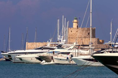Gün batımında Rodos 'taki St. Nicholas Kalesi' ndeki eski taş deniz fenerinin manzarası. Yunanistan.