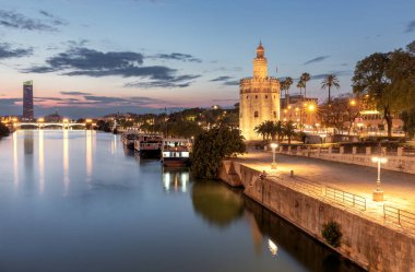 Şehir avlusunun manzarası ve gün batımında Torre del Oro 'nun altın kulesi Seville. İspanya. Endülüs.