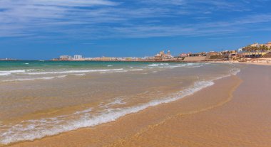 Güneşli bir günde kumlu sahil ve Atlantik Okyanusu manzarası. Cadiz. İspanya. Endülüs.