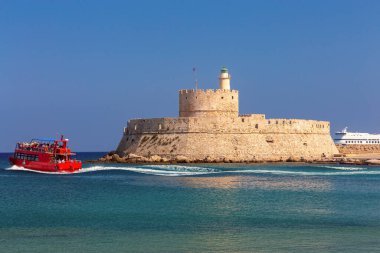 Mandrak Limanı 'ndaki mavi denize karşı güneşli eski deniz fenerinin manzarası. Rodos. Yunanistan.