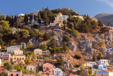 Günbatımında Yunanistan 'ın Symi kasabasında renkli geleneksel evler ve balıkçı tekneleri görülüyor. Dodekanca.