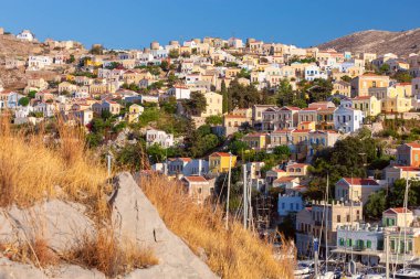 Günbatımında Yunanistan 'ın Symi kasabasında renkli geleneksel evler ve balıkçı tekneleri görülüyor. Dodekanca.