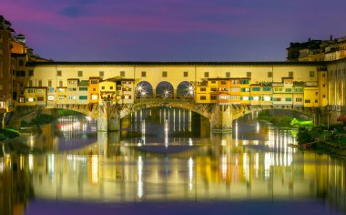 Altın Ponte Vecchio köprüsünün manzarası gece gün batımında aydınlandı. Floransa. İtalya.