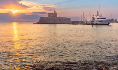 Mandrak Limanı 'ndaki eski deniz fenerinin gündoğumu manzarası. Rodos. Yunanistan.