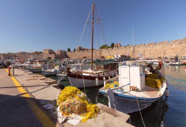 Güneşli bir günde eski Mandraki limanının balıkçı tekneleriyle manzarası. Rodos. Yunanistan.