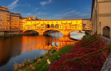 Güneş ışığıyla aydınlatılan altın Ponte Vecchio köprüsünün manzarası. Floransa. İtalya.