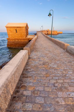 Aziz Sebastian Kalesi 'ni ve şafak vakti ona ışık tutan köprüyü görüyorum..