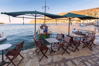 Symi köyünün seddi üzerindeki deniz kenarındaki geleneksel Yunan kafesi. Yunanistan.