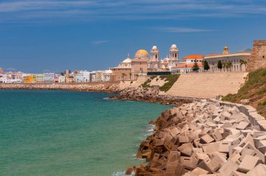 Güneşli bir günde şehrin seddindeki Kutsal Haç Katedrali 'nin kubbe ve kulelerinin manzarası. Cadiz. İspanya. Endülüs.