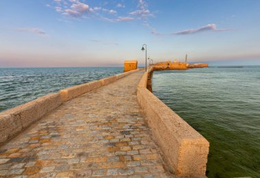 Aziz Sebastian Kalesi 'ni ve şafak vakti ona ışık tutan köprüyü görüyorum..