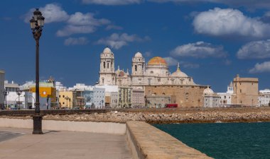 Güneşli bir günde şehrin seddindeki Kutsal Haç Katedrali 'nin kubbe ve kulelerinin manzarası. Cadiz. İspanya. Endülüs.