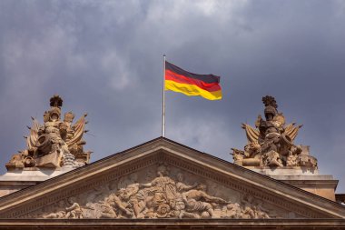 Berlin 'de güneşli bir günde mavi gökyüzüne karşı ulusal Almanya bayrağı