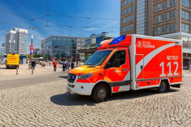 Berlin, Almanya - 21 Mayıs 2024: Sıcak ve güneşli bir günde Alexanderplatz 'da kırmızı bir ambulans görev yapıyor