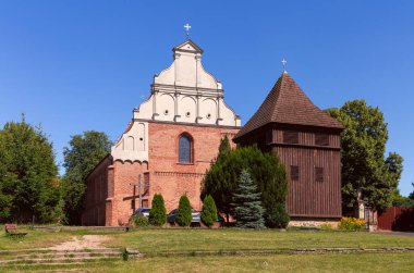 Güneşli bir günde yakınında ahşap çan kulesi olan St. Wojciech Katolik Kilisesi Poznan, Polonya