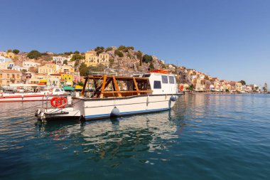 Güneşli bir günde, Suriye köyünde renkli geleneksel evler ve balıkçı tekneleri, Yunanistan ve Dodecanese manzarası.