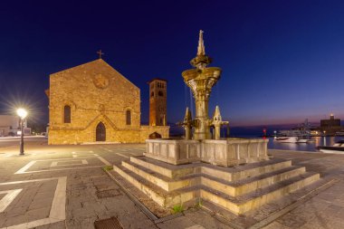 Şafakta, Rodos, Yunanistan 'da Bakire Meryem' in Anonsları Kilisesi 'nin önündeki meydanda bir çeşme.