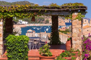 Sarmaşıklarla kaplı taş pergola ve Tossa de Mar, Katalonya, İspanya 'daki deniz ve kıyı manzaralı pitoresk teras..