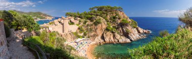 Tossa de Mar 'daki kıyı köyü ve körfezin panoramik manzarası, İspanya, Akdeniz' deki taş evler ve teknelerle.