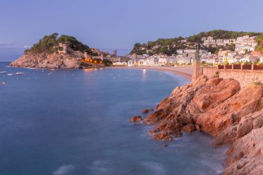 Tossa de Mar plajının manzarası ve İspanya 'nın Katalonya kıyısında gün doğumuyla aydınlanan kale.