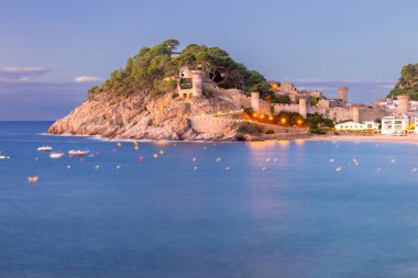 Tossa de Mar plajının manzarası ve İspanya 'nın Katalonya kıyısında gün doğumuyla aydınlanan kale.