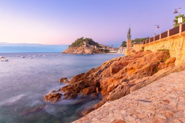 Tossa de Mar plajının manzarası ve İspanya 'nın Katalonya kıyısında gün doğumuyla aydınlanan kale.
