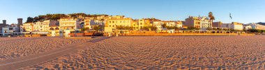 Güneş doğarken Tossa de Mar kıyı şeridinin panoramik manzarası, binalar ve kumlu plajlar, Katalonya, İspanya