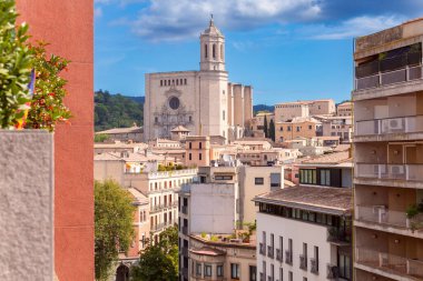 Aziz Meryem Katedrali 'nin eski kasabadaki kulesi çevredeki binaların çatılarının üzerinde yükselmekte açık bir gökyüzüne, Girona' ya, İspanya 'ya, Katalonya' ya karşı