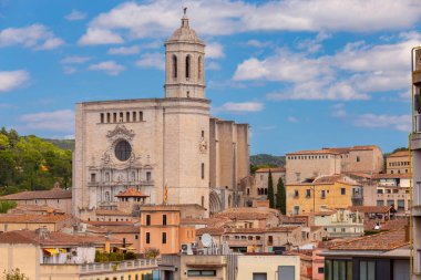 Aziz Meryem Katedrali 'nin eski kasabadaki kulesi çevredeki binaların çatılarının üzerinde yükselmekte açık bir gökyüzüne, Girona' ya, İspanya 'ya, Katalonya' ya karşı