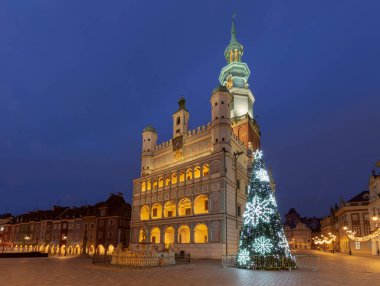 Poznan, Polonya 'nın Eski Pazar Meydanı' ndaki Poznan Belediye Binası 'nın sabahın erken saatlerinde Noel ışıkları ve güneş doğmadan hemen önce dekore edilmiş bir ağaçla aydınlandı.