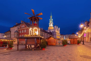 Polonya 'nın Poznan kentindeki Eski Pazar Meydanı' nda, aydınlatma tezgahları ve geleneksel ahşap piramitlerle sabah erkenden Noel pazarının manzarası