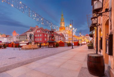 Poznan, Polonya 'nın Eski Pazar Meydanı' ndaki Poznan Belediye Binası 'nın sabahın erken saatlerinde Noel ışıkları ve güneş doğmadan hemen önce dekore edilmiş bir ağaçla aydınlandı.