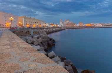 İspanya 'nın Cadiz kentindeki sahil şeridi, şafak vakti, arka planda Cadiz Katedrali bulunan tarihi şehir manzarası