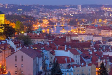 Vltava Nehri 'nin akşam manzarası ve Çek Cumhuriyeti' nin kırmızı çatılarıyla aydınlatılmış şehir manzarası