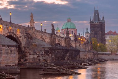 Çek Cumhuriyeti Prag 'daki Charles Köprüsü' nün sabahın erken saatlerinde aydınlatmalı sokak lambaları ve tarihi kuleleri