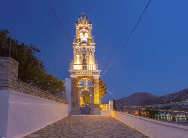 Yunanistan 'ın Symi kentindeki Başmelek Manastırı' nın aydınlık çan kulesi Michael Panormitis 'in alacakaranlığında.