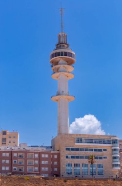 Cadiz İspanya 'daki modern telekomünikasyon kulesi açık mavi gökyüzü altındaki binaların üzerinde yükseliyor
