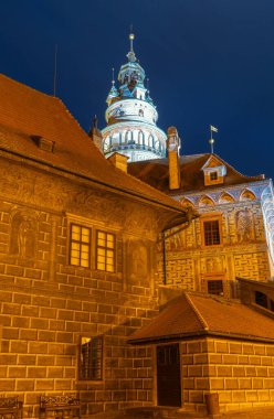 Çek Cumhuriyeti 'nin Cesky Krumlov şehrinde geceleyin aydınlık kule ve eski binalar