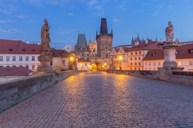 Şafak vakti Çek Cumhuriyeti Prag 'da heykeller ve fenerlerle Charles Köprüsü manzarası
