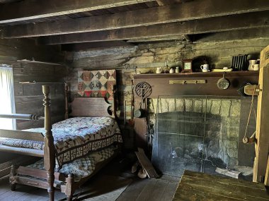 1800 'lerin evinde şömine, masa ve yataklar. Mitchell, Indiana yakınlarındaki Spring Mill Parkı' ndaki yenilenmiş ve yenilenmiş Pioneer Village 'da..